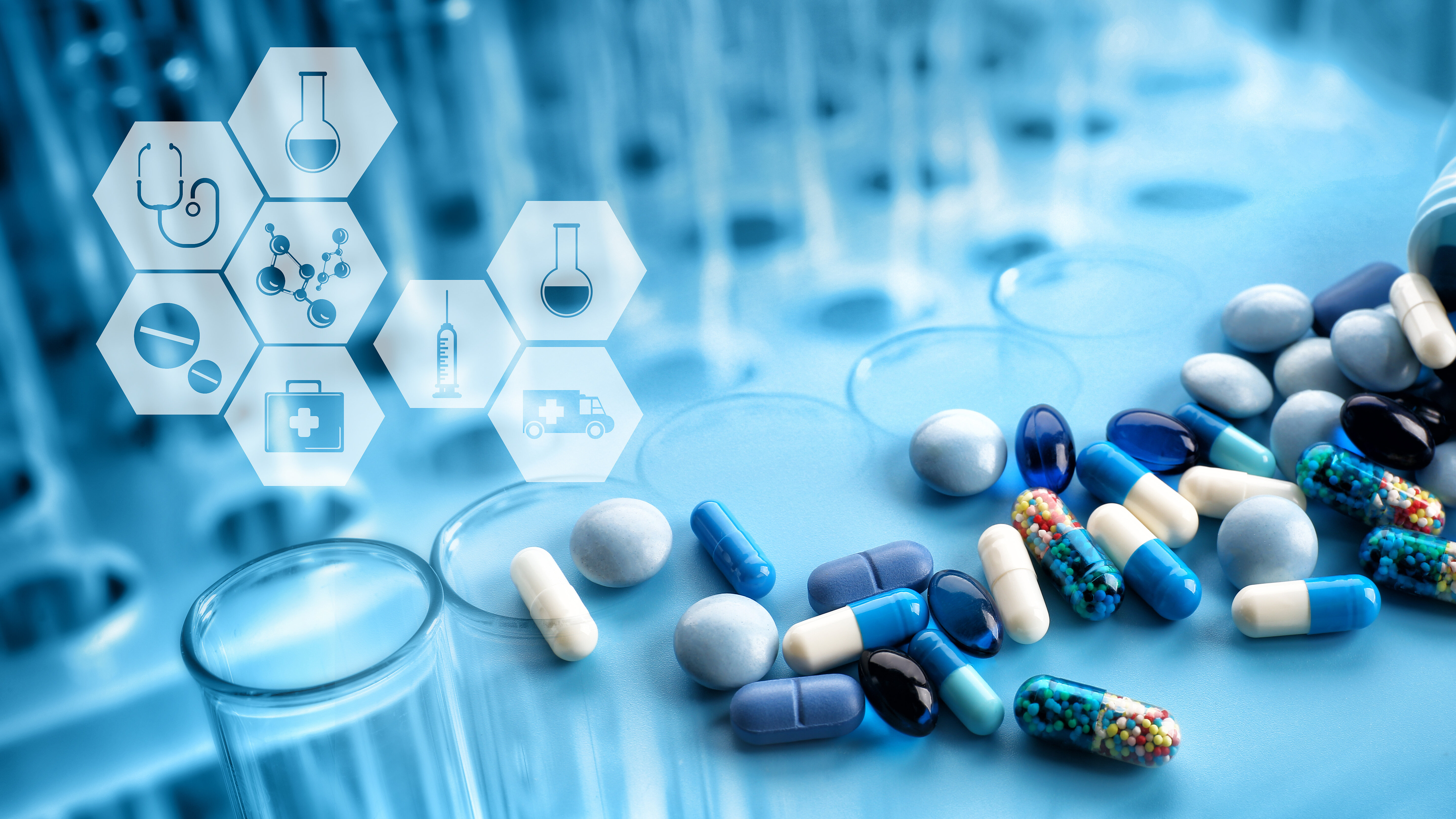 Close-up of various tablets, capsules, and medicinal products on a laboratory surface with test tubes in the background. Overlayed healthcare icons, including a stethoscope, syringe, molecular structure, laboratory flask, and emergency care symbols, illustrate pharmaceutical research, drug development, healthcare services, and medical innovation.