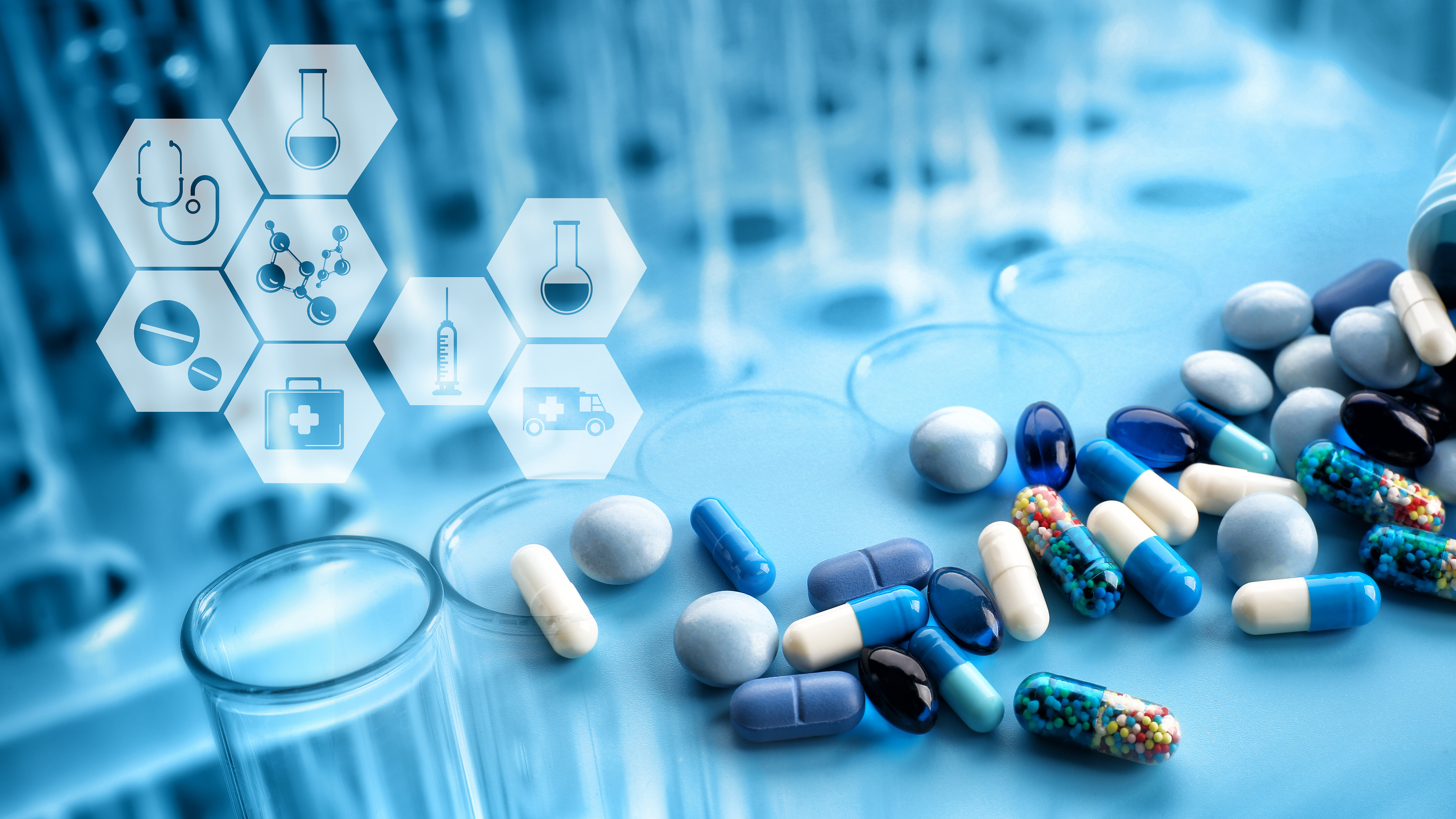 Nahaufnahme verschiedener Tabletten, Kapseln und Arzneiformen auf einer Laboroberfläche mit Reagenzgläsern im Hintergrund. Eingeblendete medizinische Symbole wie Stethoskop, Spritze, Molekülstruktur, Laborflasche und Notfallversorgung veranschaulichen pharmazeutische Forschung, Arzneimittelentwicklung, Gesundheitsversorgung und medizinische Innovation.